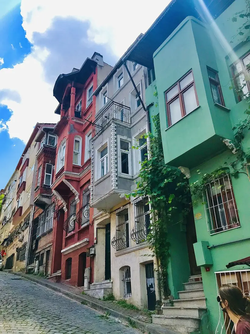 Pastel terraces on a Balat slope, shot from the low end of the street so the facades stack into one wall of colour. Photo: Maurice Flesier / Wikimedia Commons / CC BY-SA 4.0